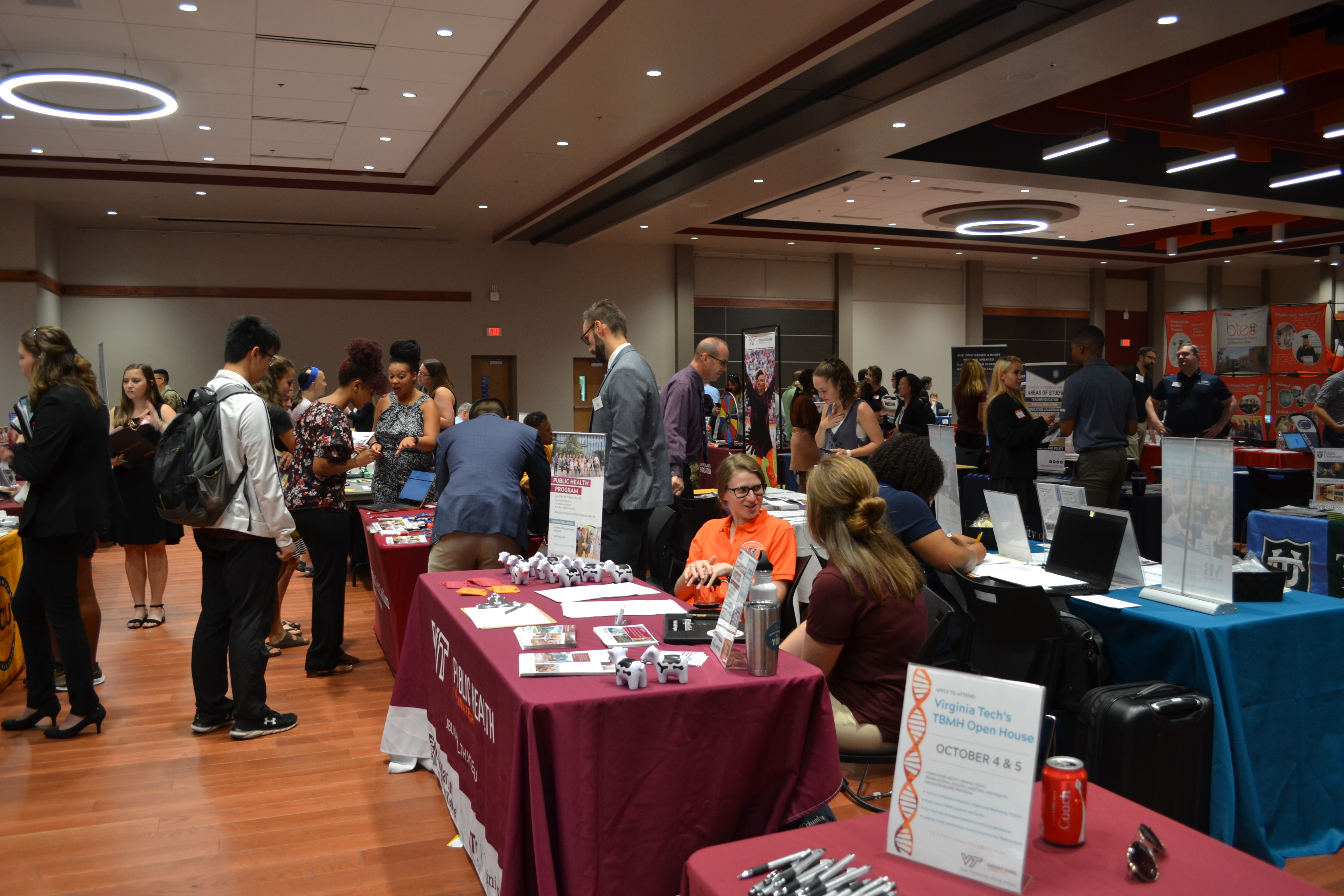 students gathered at tables at grad fair