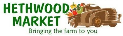 logo for hethwood market featuring an old fashioned brown truck heavily laden with fresh produce with the words bringing the fame to you below the name and image