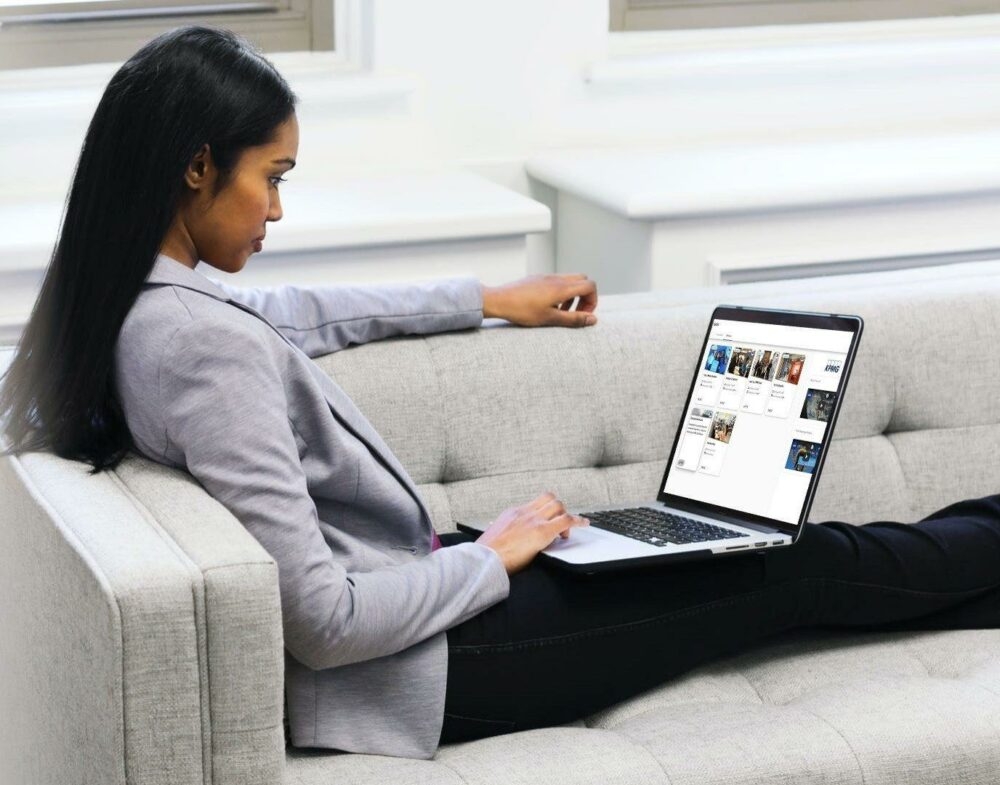 woman lounging on couch, using laptop